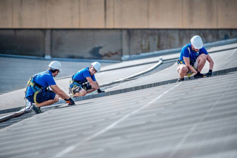 Commercial roof inspections being completed by roofing contractors on a large commercial building